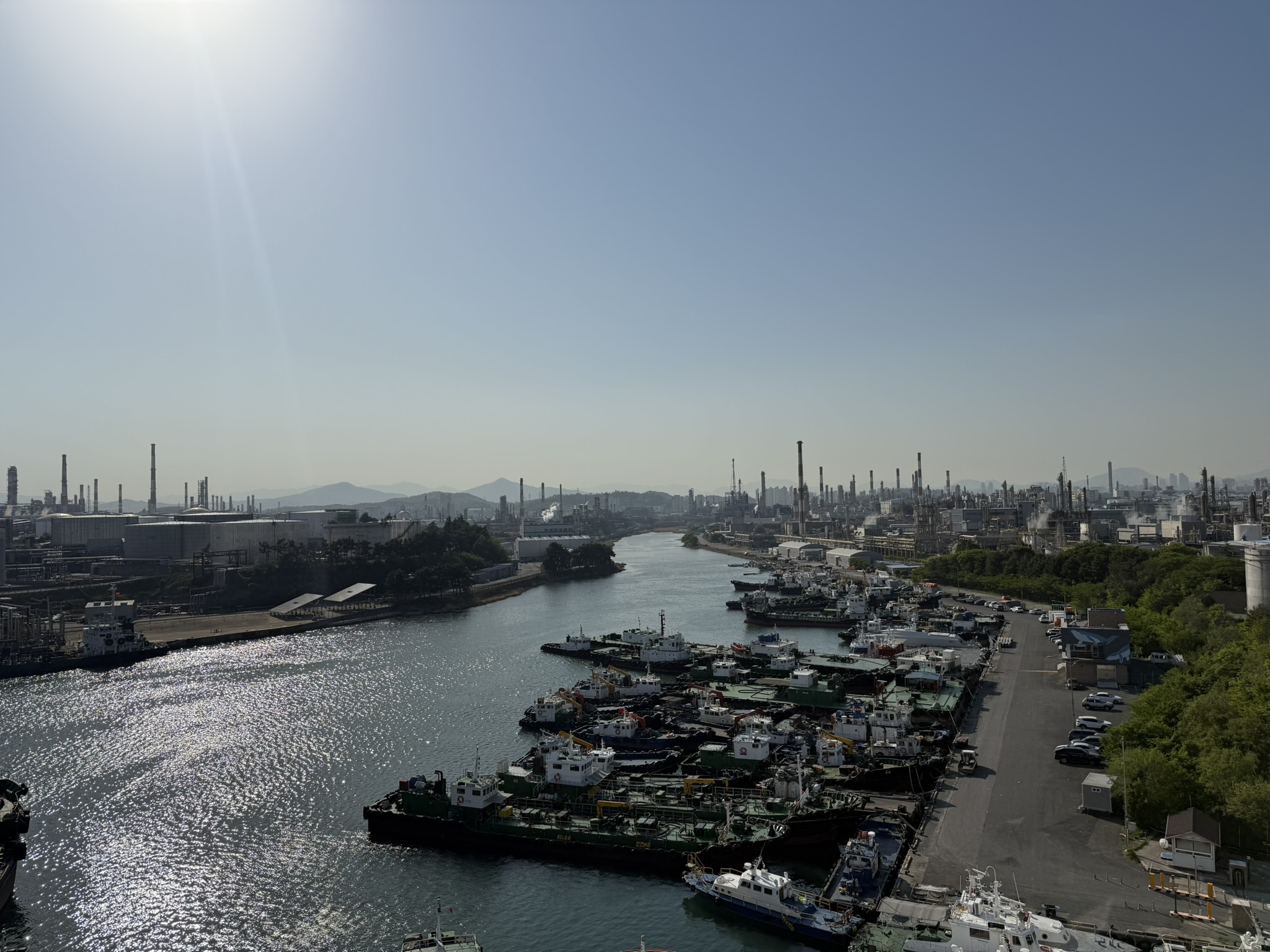 An industrial harbour in Ulsan, South Korea, with fishing boats and refineries along the water